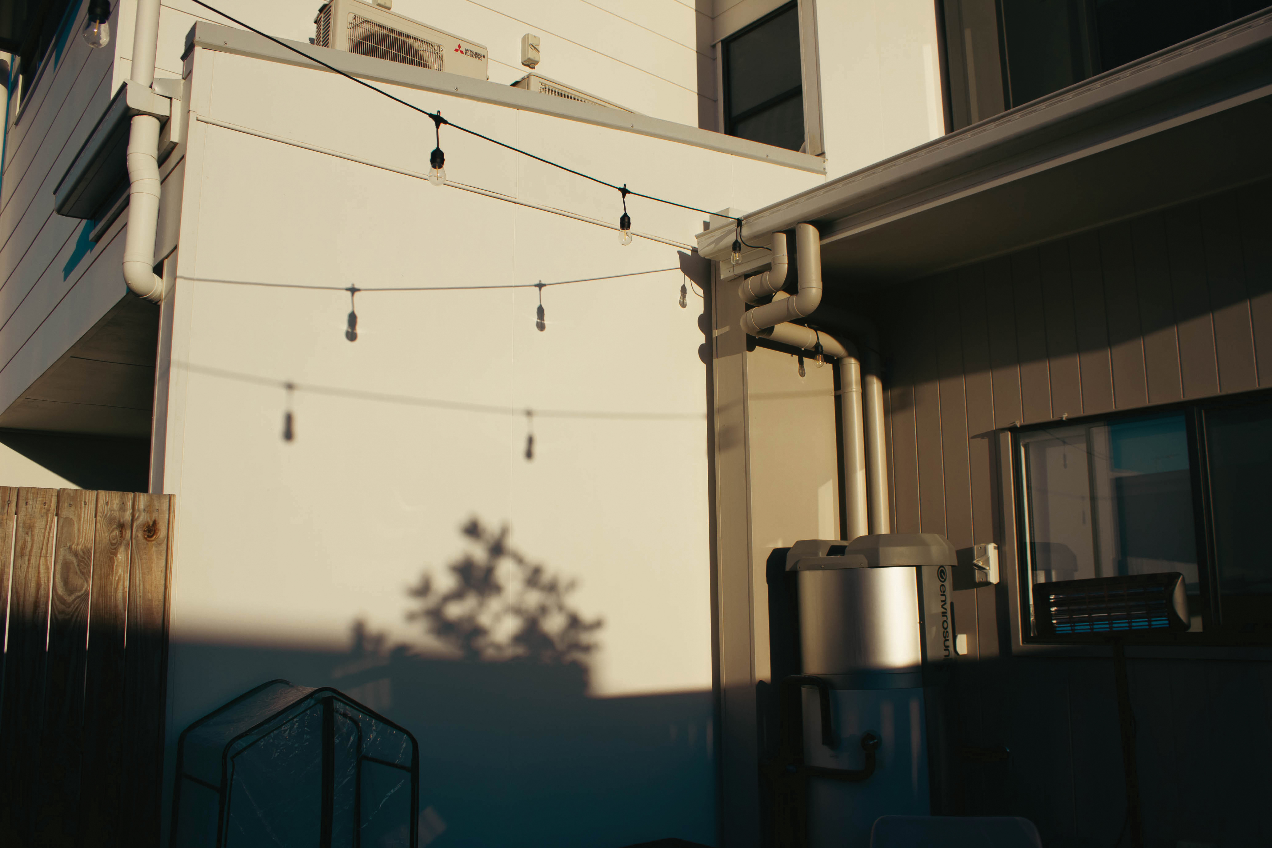 A backyard at golden hour with shadows of a tree