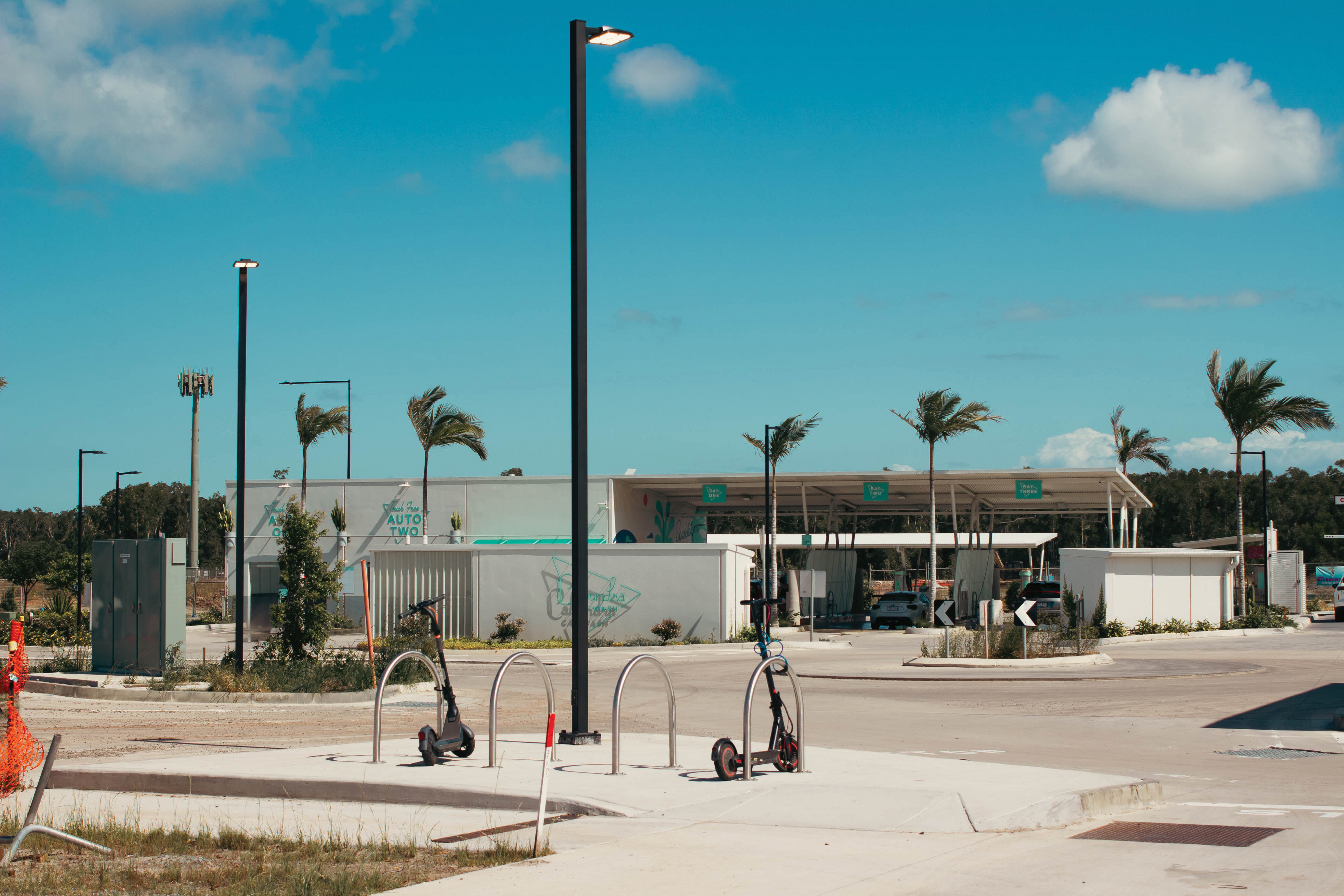 A car wash with palm trees and electric scooters outside